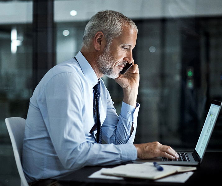 Man at computer on the phone