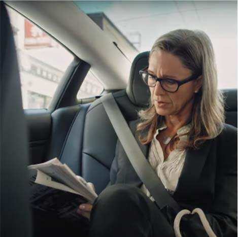 Woman in car looking at phone