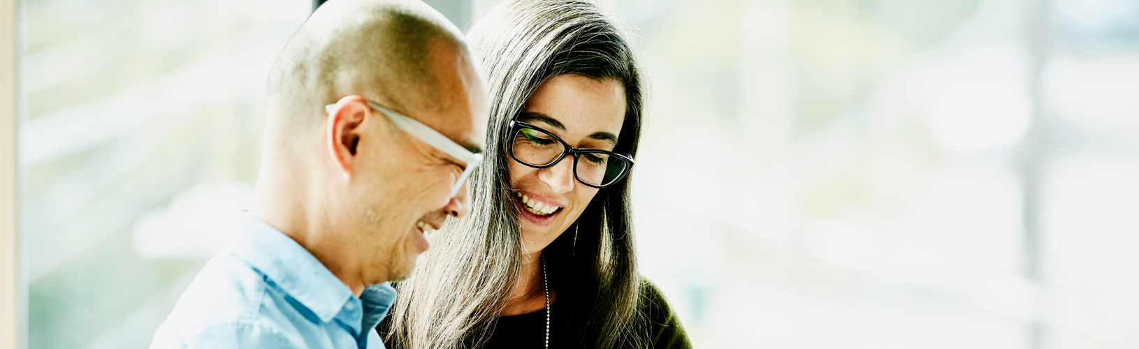 Man and woman discuss the business value of continuous monitoring in front of a window