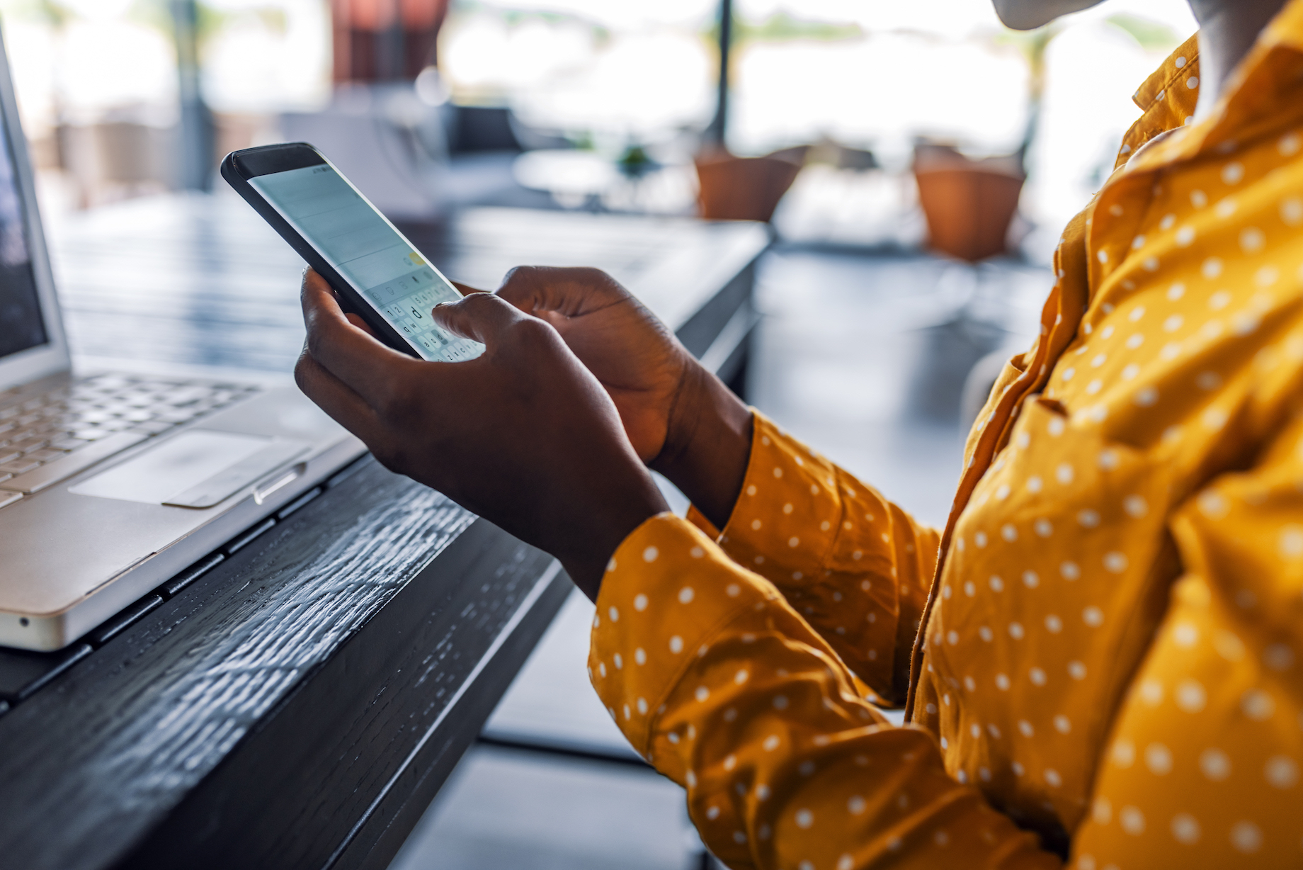 Woman using phone and laptop