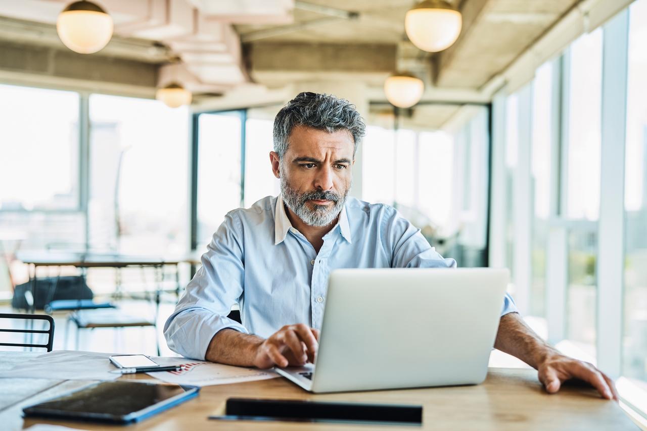A male CISO reads about the newest cybersecurity rules issued by the New York State Department of Financial Services