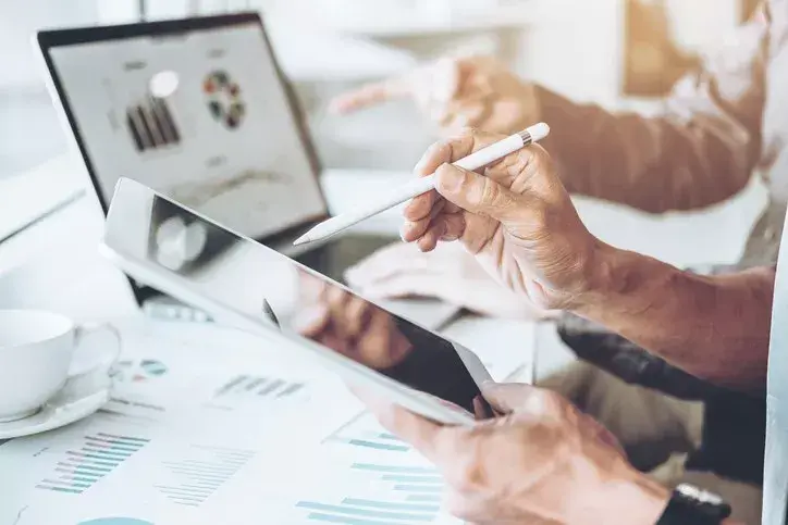 A tablet and laptop showing pie charts.